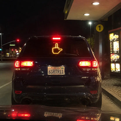 Honk Hand middle finger gesture glowing in a rear window at night